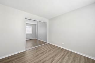 A room with a sliding glass door and wooden flooring.
