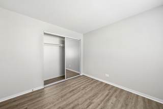 A room with a sliding door and wooden flooring.