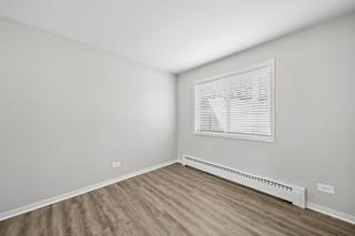 A room with a window and a radiator on the wall.