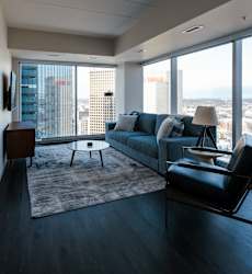 A living room with a couch, chair, and a table with a lamp on it.