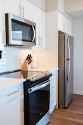 A modern kitchen with a black oven and white cabinets.