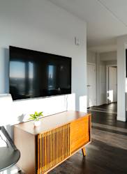 A modern living room with a flat screen TV mounted on the wall.