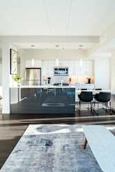 A modern kitchen with a large island and chairs.
