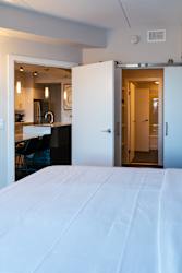A white bed with a white sheet on it.