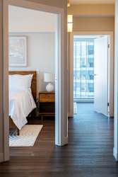 A bedroom with a bed, nightstand, and lamp.