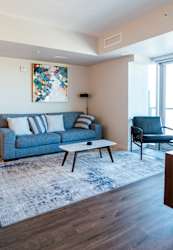 A blue couch with a floral print on the wall behind it.