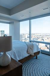 A bedroom with a large bed and a view of the city.
