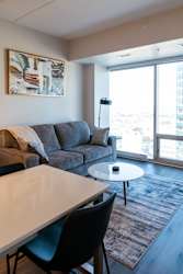 A living room with a grey couch and a white table.