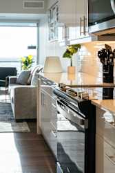 A modern kitchen with a large island and a dining area with a couch and chairs.