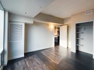 a bedroom with a medium hardwood floor and white walls