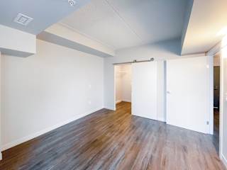 a bedroom with a closet and hardwood floors