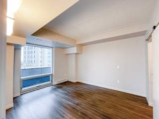 a bedroom with hardwood flooring and a large window