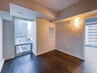 a bedroom with a large window and hardwood floors