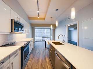 a kitchen with white countertops and stainless steel appliances