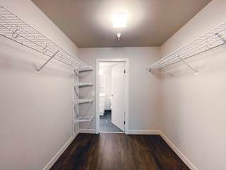 a bedroom with white walls and a wooden floor