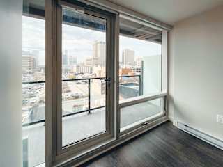 a bedroom with a large window and a balcony