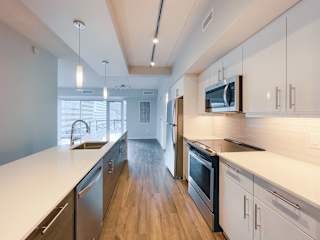 a kitchen with white countertops and stainless steel appliances