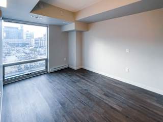 a bedroom with hardwood floors and a large window