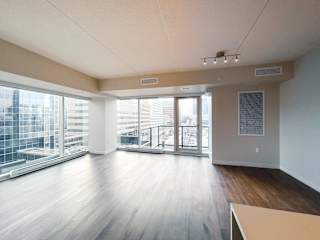 an empty living room with hardwood floors and a balcony