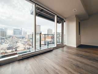 an empty living room with a large window and a view of the city