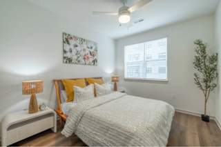 A bedroom with a large bed and a ceiling fan.