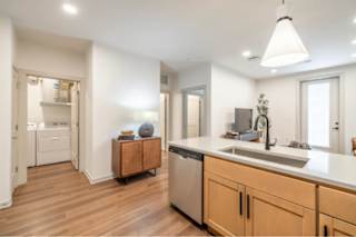 A modern kitchen with wooden floors and a large island.