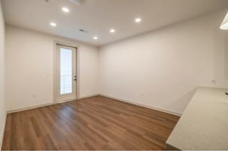 A room with wooden flooring and a white door.