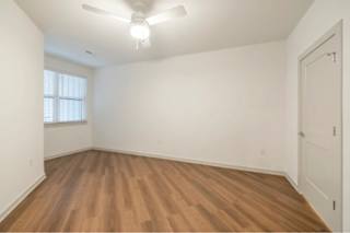 A room with wooden flooring and a ceiling fan.