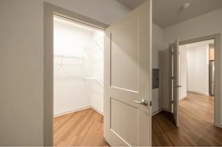 A white door is open to a room with wooden floors.