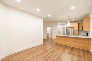 A kitchen with wooden floors and white walls.