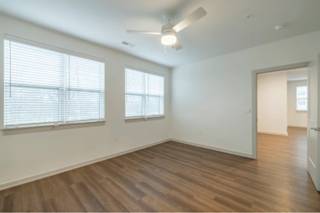 A room with wooden floors and a ceiling fan.