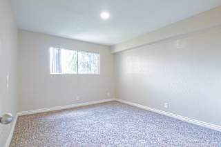 a bedroom with white walls and carpet