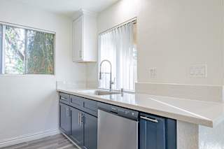 a kitchen with white walls and blue cabinets