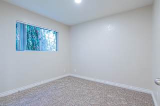 a bedroom with white walls and a window