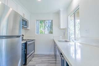 a kitchen with white cabinets and stainless steel appliances