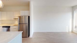 an empty kitchen with a stainless steel refrigerator