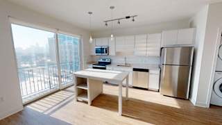 a white kitchen with a large window and a table