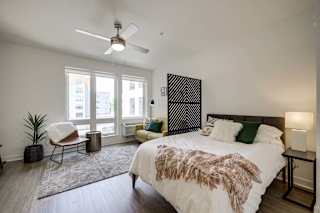 a bedroom with a large bed and a ceiling fan