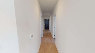 a hallway with a wood floor and white walls