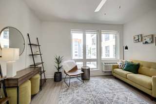a living room with a couch and a chair and a window