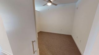 an empty room with a ceiling fan and a carpet