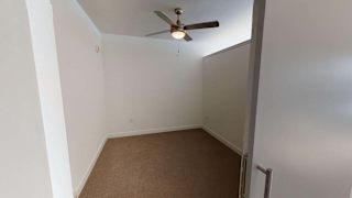 an empty room with a ceiling fan and a door