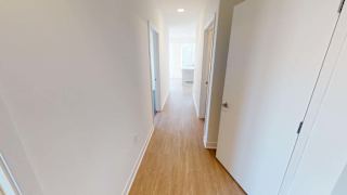 a hallway with white walls and a wooden floor