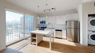 a white kitchen with a table and a washing machine