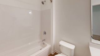 a white bathroom with a toilet and a tub