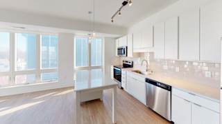 a large kitchen with white cabinets and stainless steel appliances