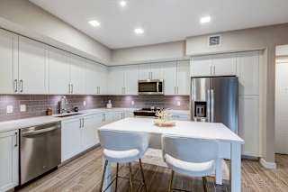 A modern kitchen with a white table and chairs.