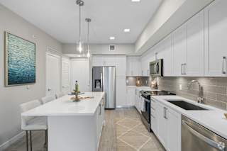 A modern kitchen with white cabinets and a large island.