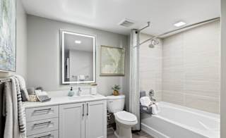 A bathroom with a white tub, sink, and toilet.