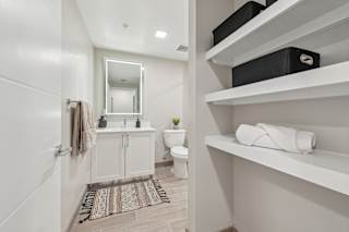 A bathroom with a toilet, sink, and mirror.